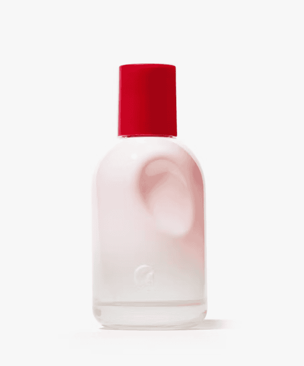 A pink and white bottle of glossier perfume with a red cap.