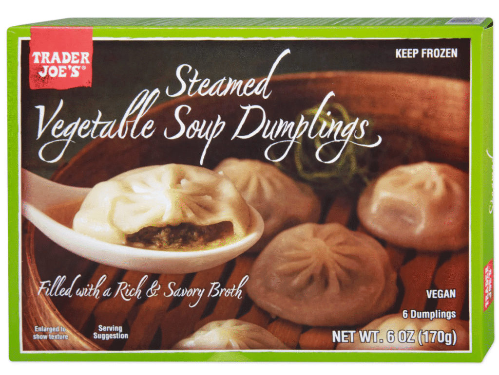 A box of steamed vegetable dumplings with a spoon picking one up on the front