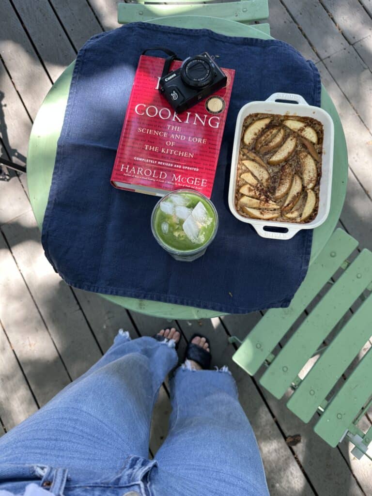 An image of a table with baked oats, matcha, and a book.