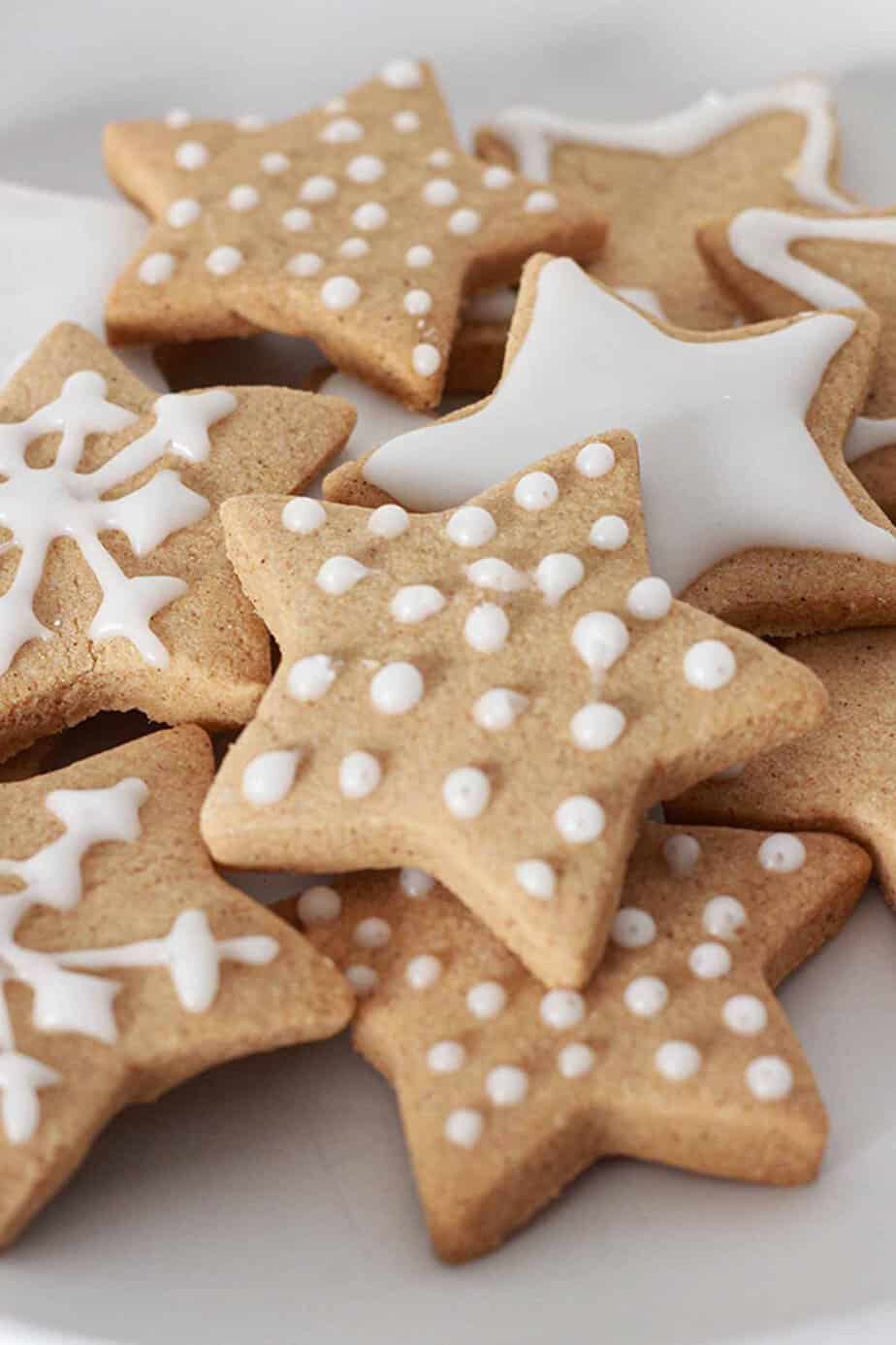 A plate of star shaped cookies with icing.