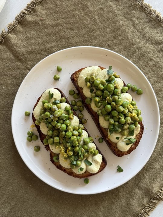 Two slices of sourdough topped with a tofu ricotta and peas