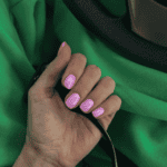 Pink nails with green sweatpants in the background