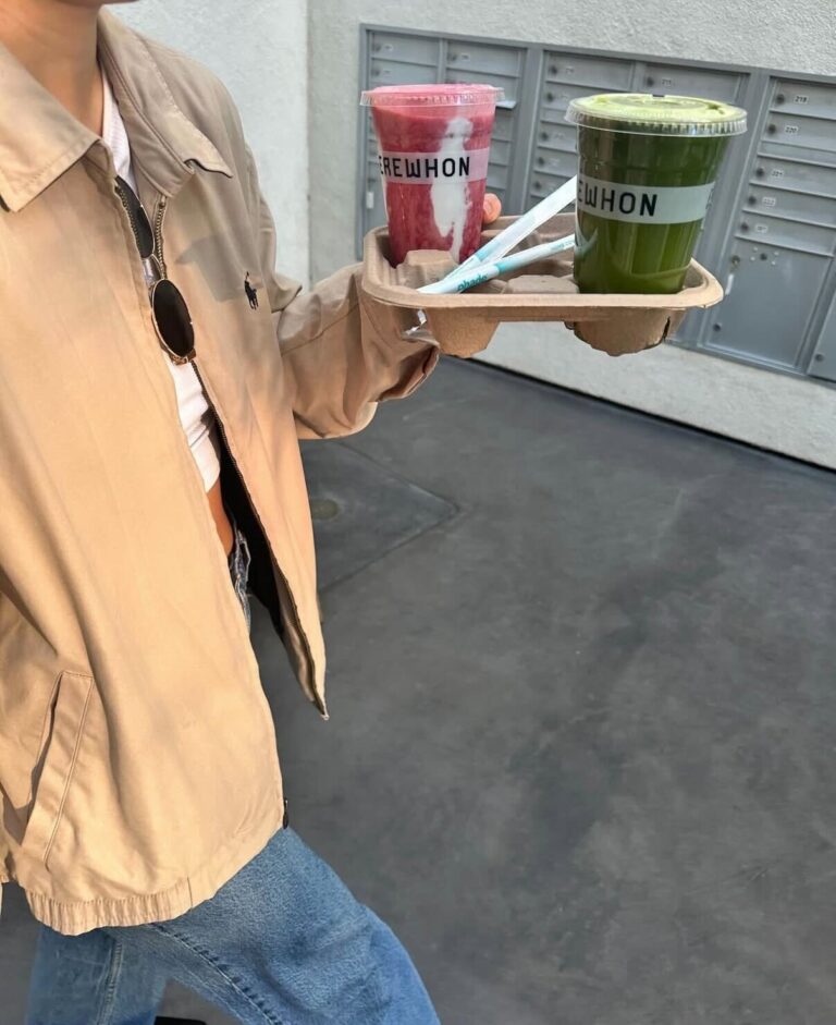 Girl holding smoothies in a lightweight jacket and jeans