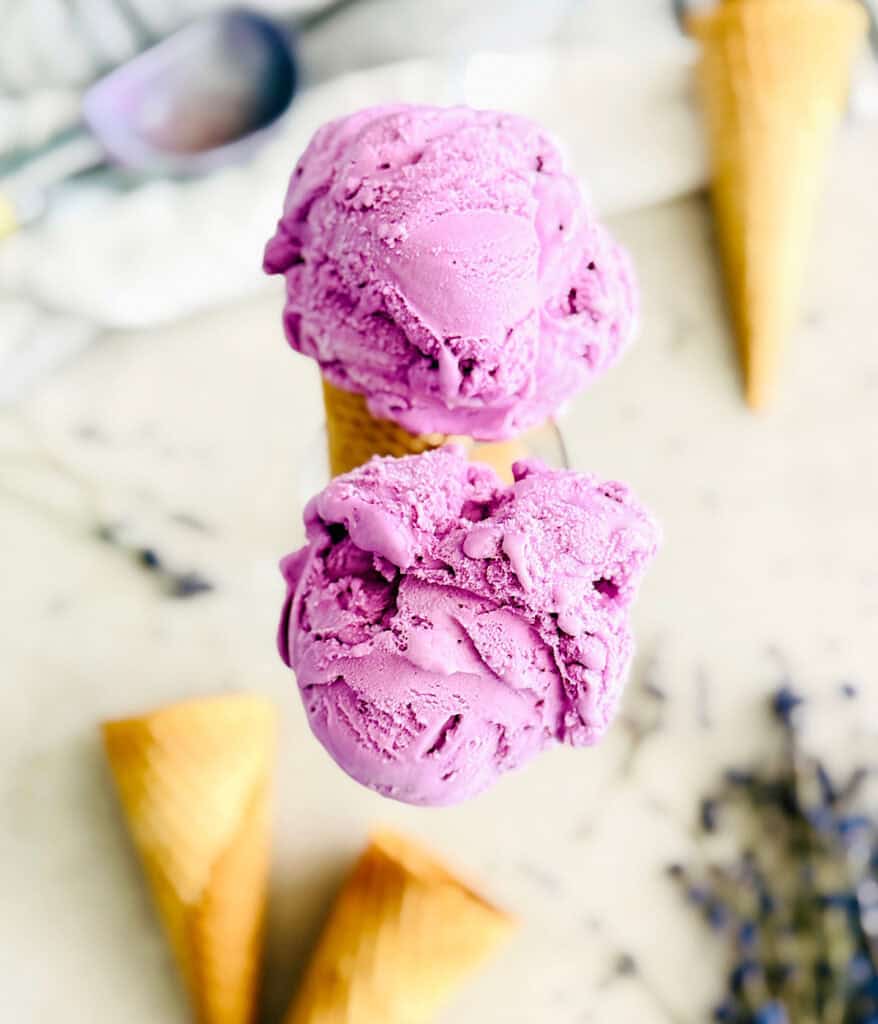 Two bright purple scoops of ice cream in cones