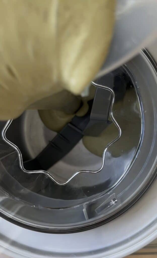 Pouring the chilled ice cream based into the freezer bowl.