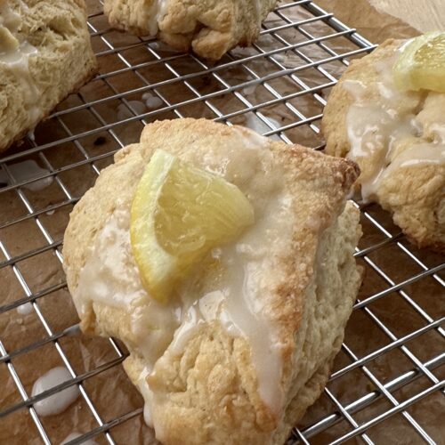 Close up of lemon scones with a lemon wedge on top