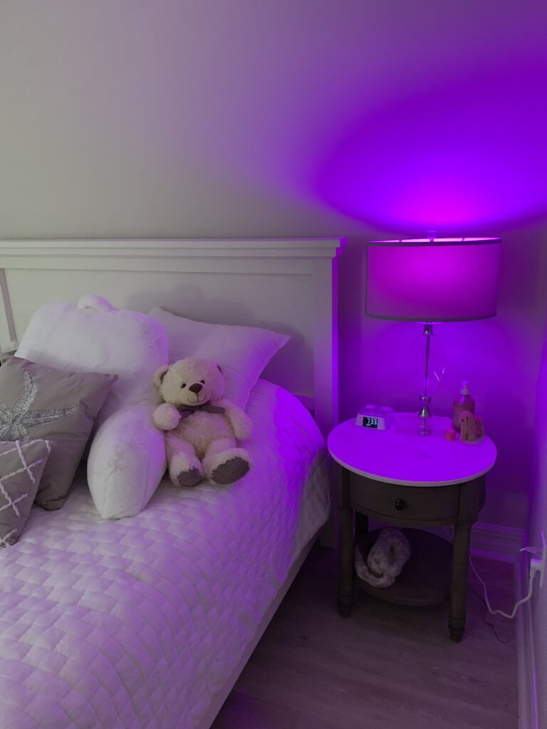 Purple mood lighting from a lamp in a bedroom 