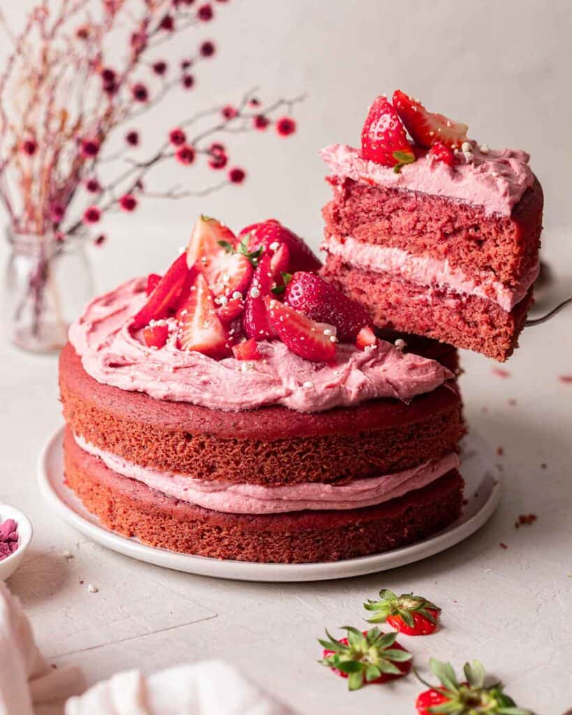 Strawberry cake with strawberry frosting and topped with strawberry slices.