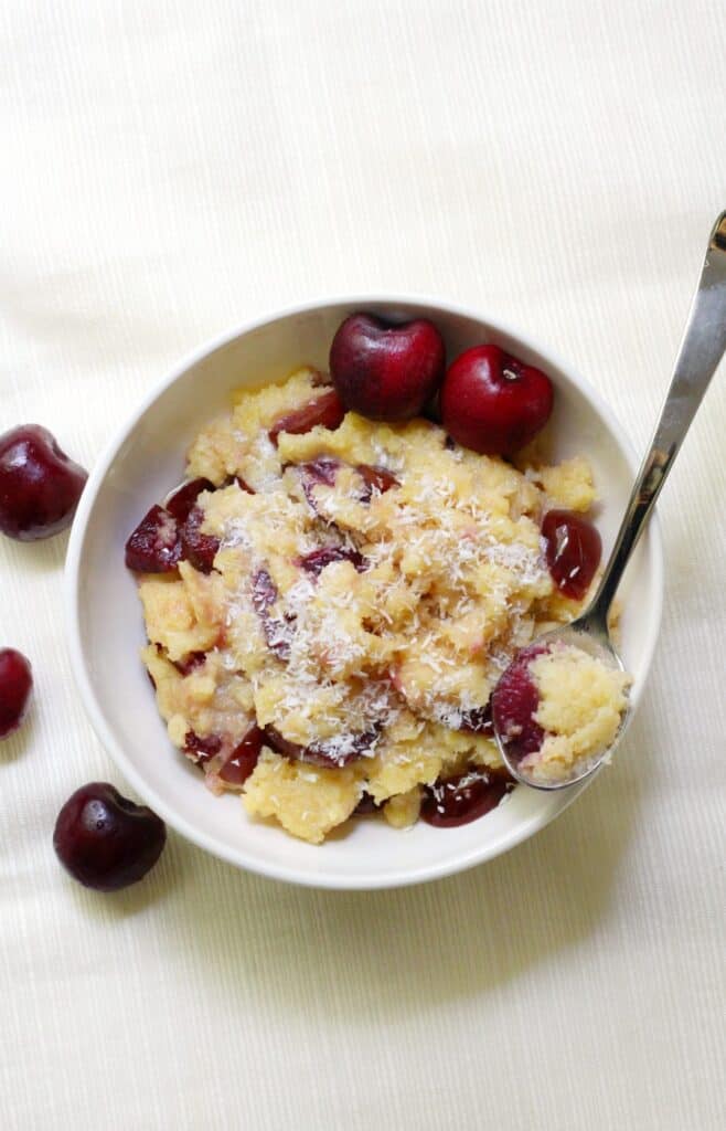A top down shot of a bowl of cherry coconut polenta