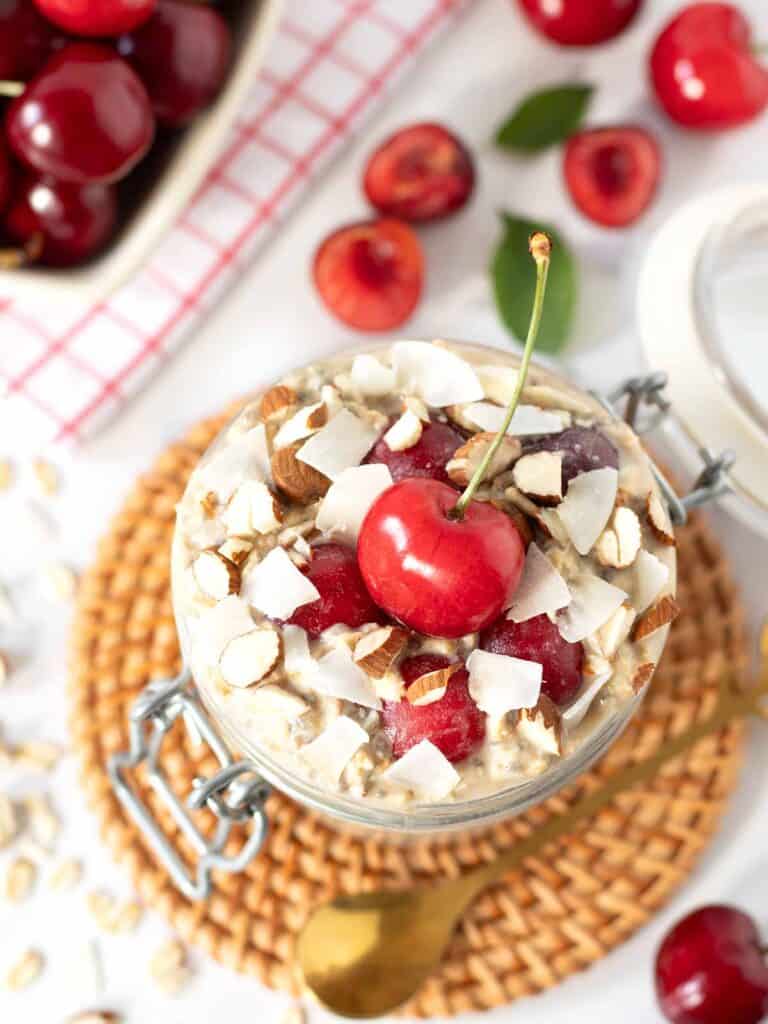 A top down shot of cherry overnight oats topped with cherries and almonds
